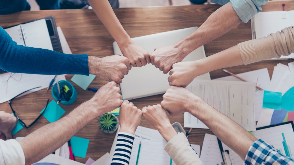Equipo colaborando en una mesa de trabajo